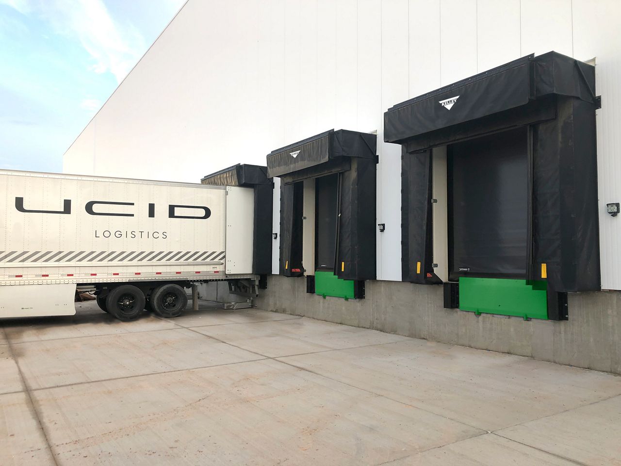 A line of Kelley FSR1000 FoamSide Dock Shelter installed outside with a trailer backed into one of the shelters.
