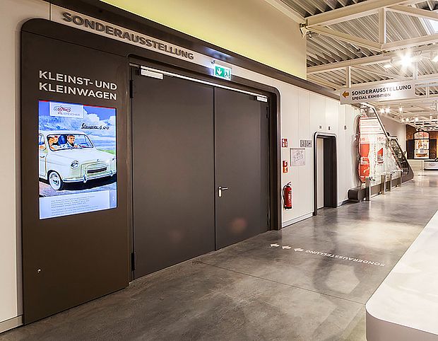 Doppelflügelige Tür mit Werbereklame in einer Ausstellungshalle