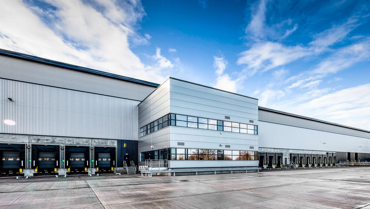 A row of loading bays featuring an ASSA ABLOY dock door, dock leveller and shelter