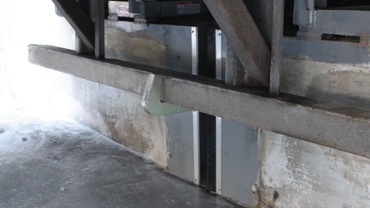 Close up of the Hidden Hook in use restraining a trailer outside of a warehouse.