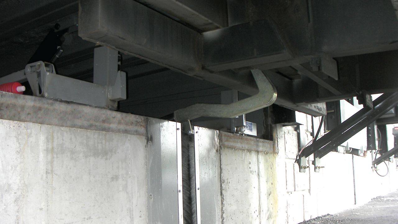  Bottom view of the Hidden Hook in use restraining a trailer outside of a warehouse.