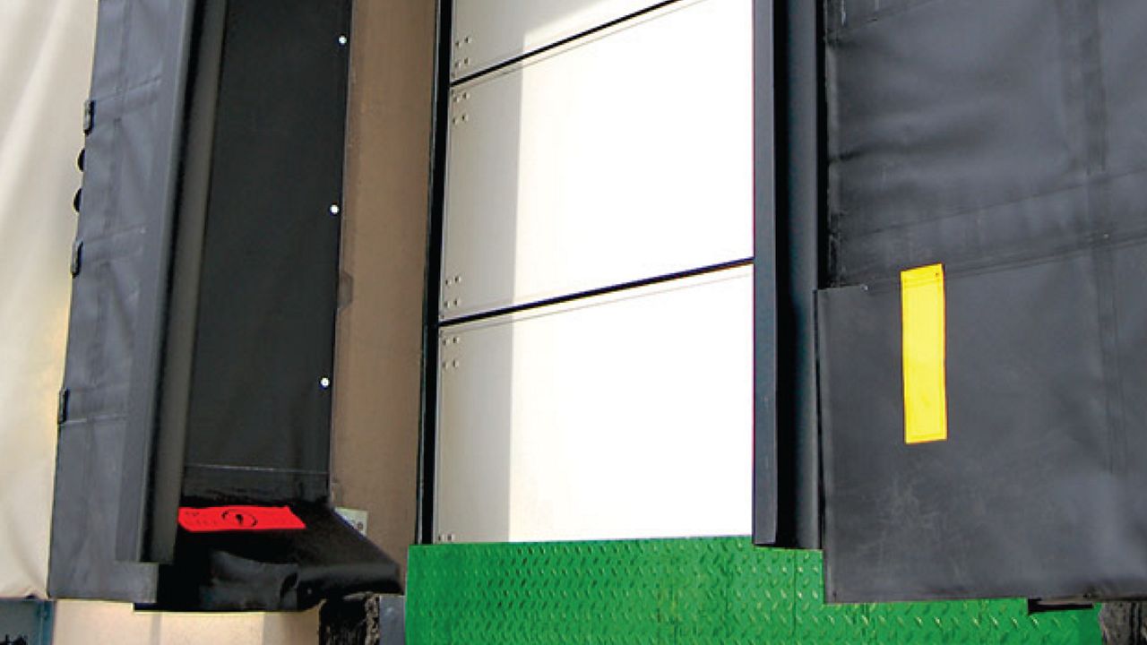 A dock shelter system that automatically activates when a trailer backs in, grasping the sides of the trailer to cover hinge gaps, creating a consistent seal from top to bottom.