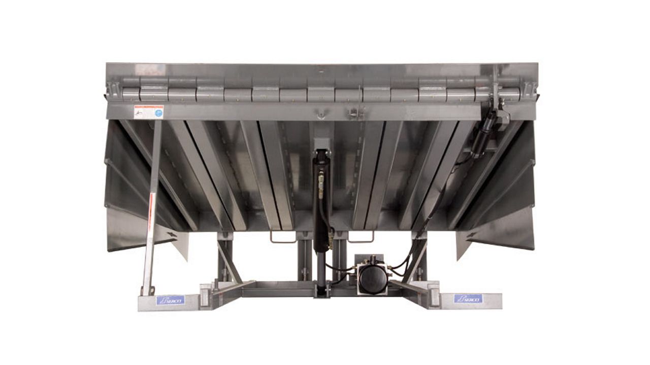 A silver hydraulic dock leveler with side panels.