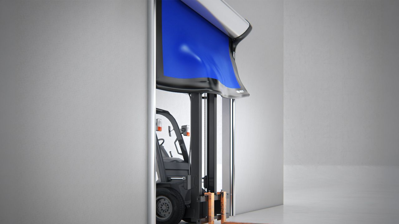 Image: Porta Rápida para Indústria Alimentícia ASSA ABLOY HS9130G, azul com estrutura em aço inoxidável, instalada em área industrial de movimentação de cargas, permitindo a passagem de empilhadeira com pallet e contribuindo para o controle de temperatura, higie