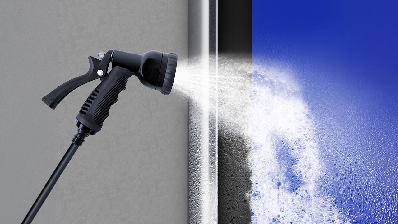 Image: Porta Rápida para Indústria Alimentícia ASSA ABLOY HS9130G, azul com superfície lavável e estrutura em aço inoxidável, demonstrada durante procedimento de higienização com jato de água para atender aos requisitos de limpeza e segurança em ambientes de pro