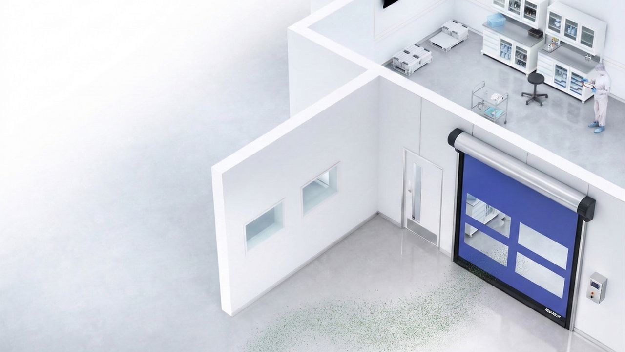 Image: Porta Rápida para Sala Limpa ASSA ABLOY HS9130GAT, azul com janelas transparentes instalada na entrada de uma área limpa, conectando ambientes controlados de laboratório e produção farmacêutica.