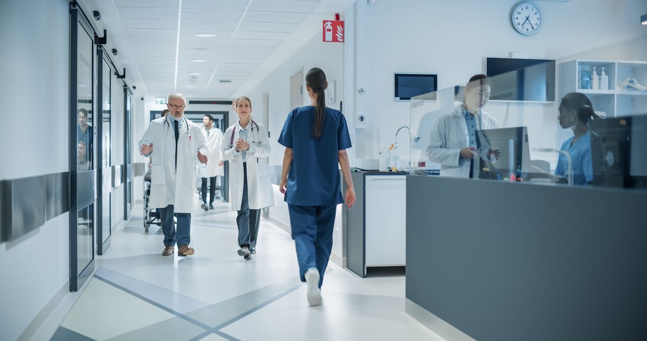 Healthcare workers walking in hospital corridor