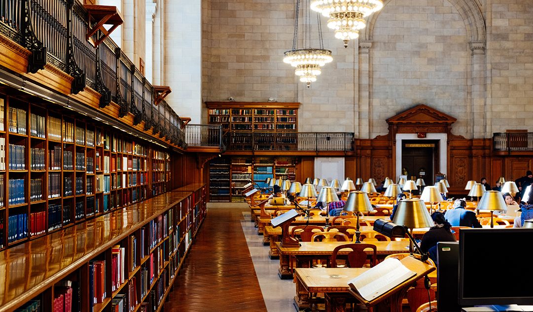 A university library with desks and students studying.