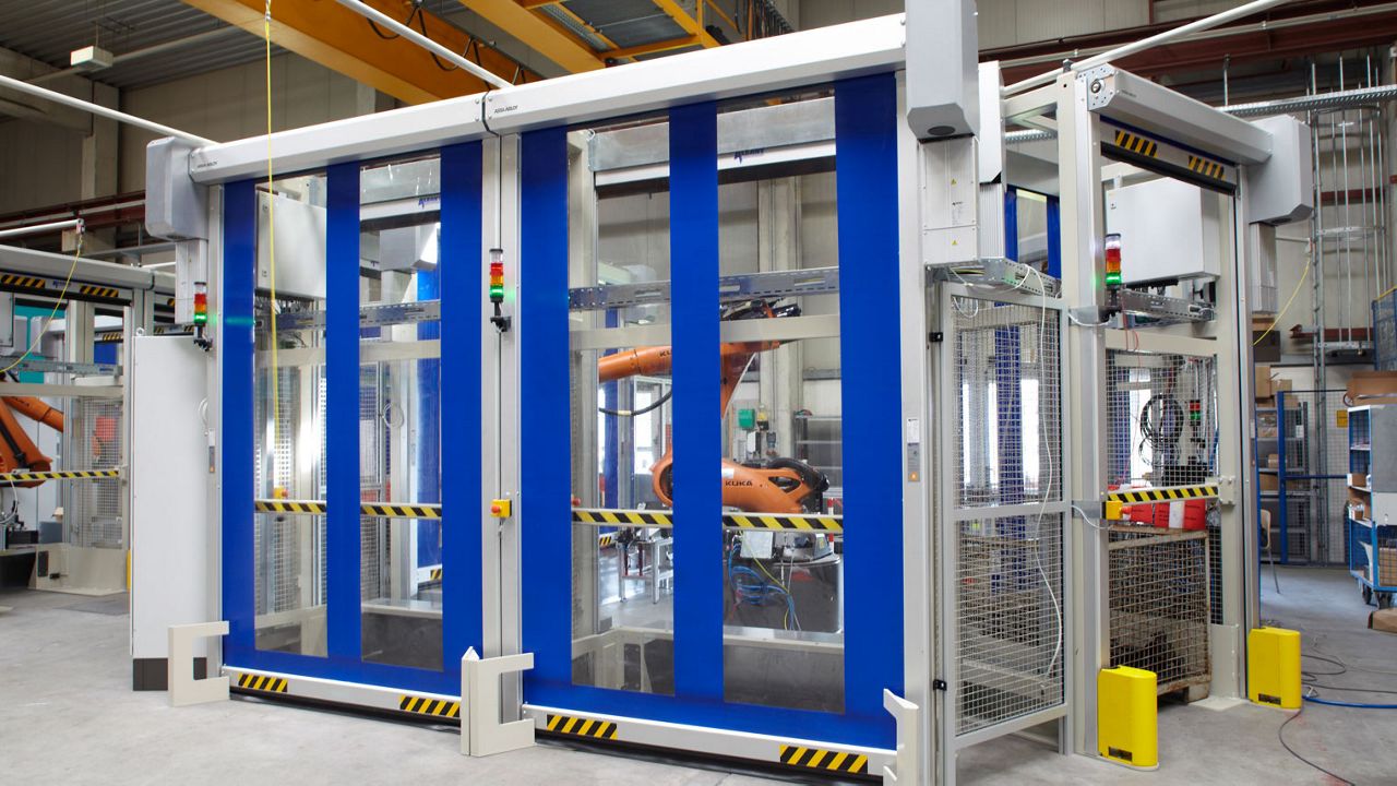 Puertas rápidas azules para protección de máquinas en una industria.