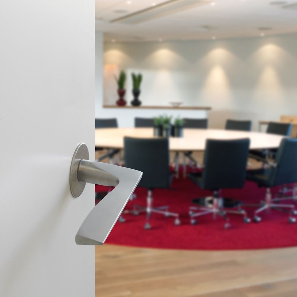 Et Holgaard dørgreb fra ASSA ABLOY på dør til konferencerum