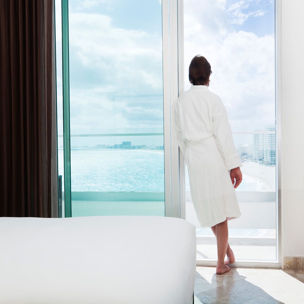 woman standing at a sliding door | hospitality-guest-room solutions