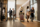 A group of business people walking through a lobby hotel, engaged in conversation and carrying briefcases.