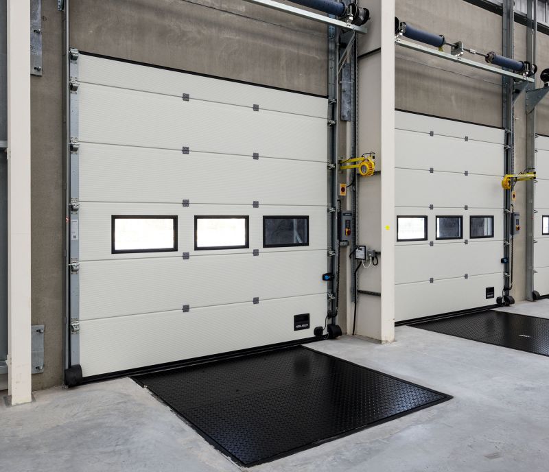 Zwei Sektionaltore mit Fenster und Ladebrücken in einer Halle