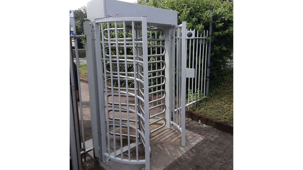 Image: Hoog draaihekken type FT400 aan de inkom van een bedrijfspand, gezien vanuit een andere hoek.