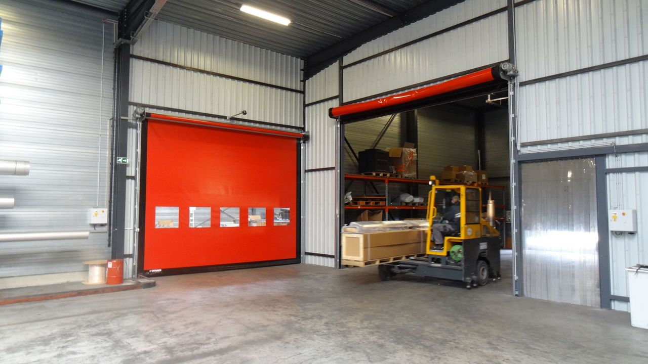 A truck that is driving through a red door.