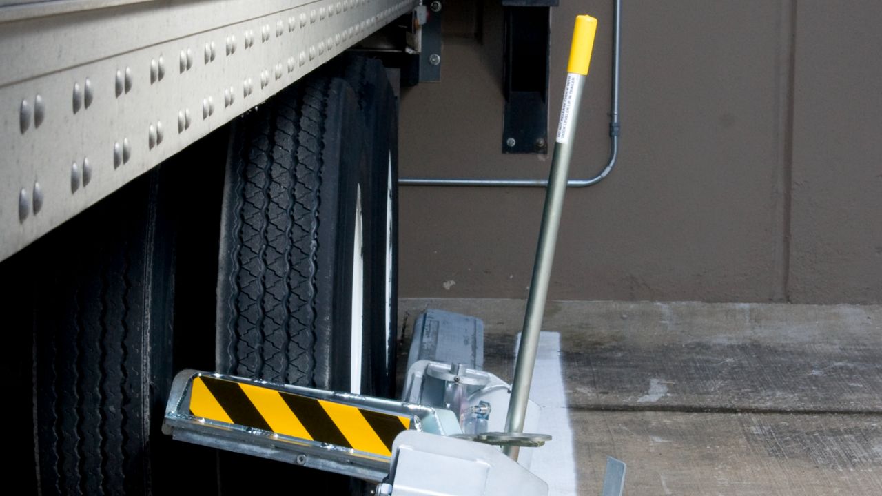 A manually operated, surface-mounted device for efficient wheel anchoring.