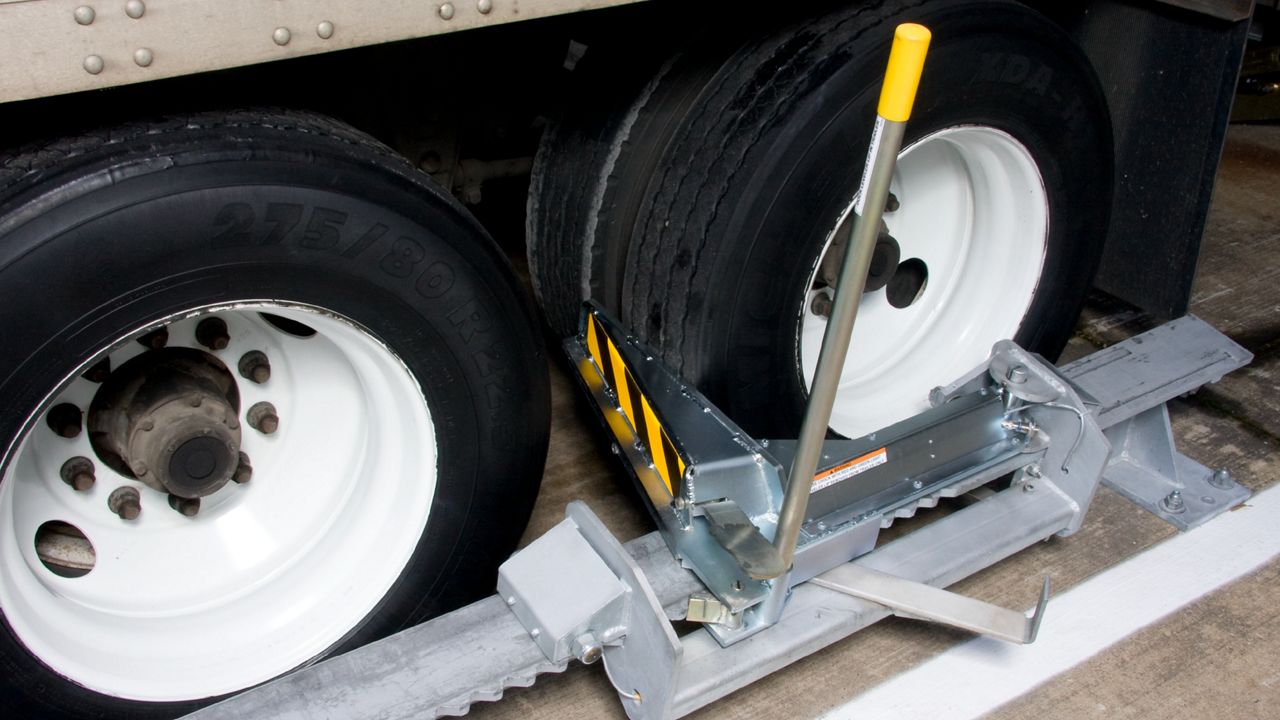 Close-up of a manually operated, surface-mounted device for efficient wheel anchoring. 