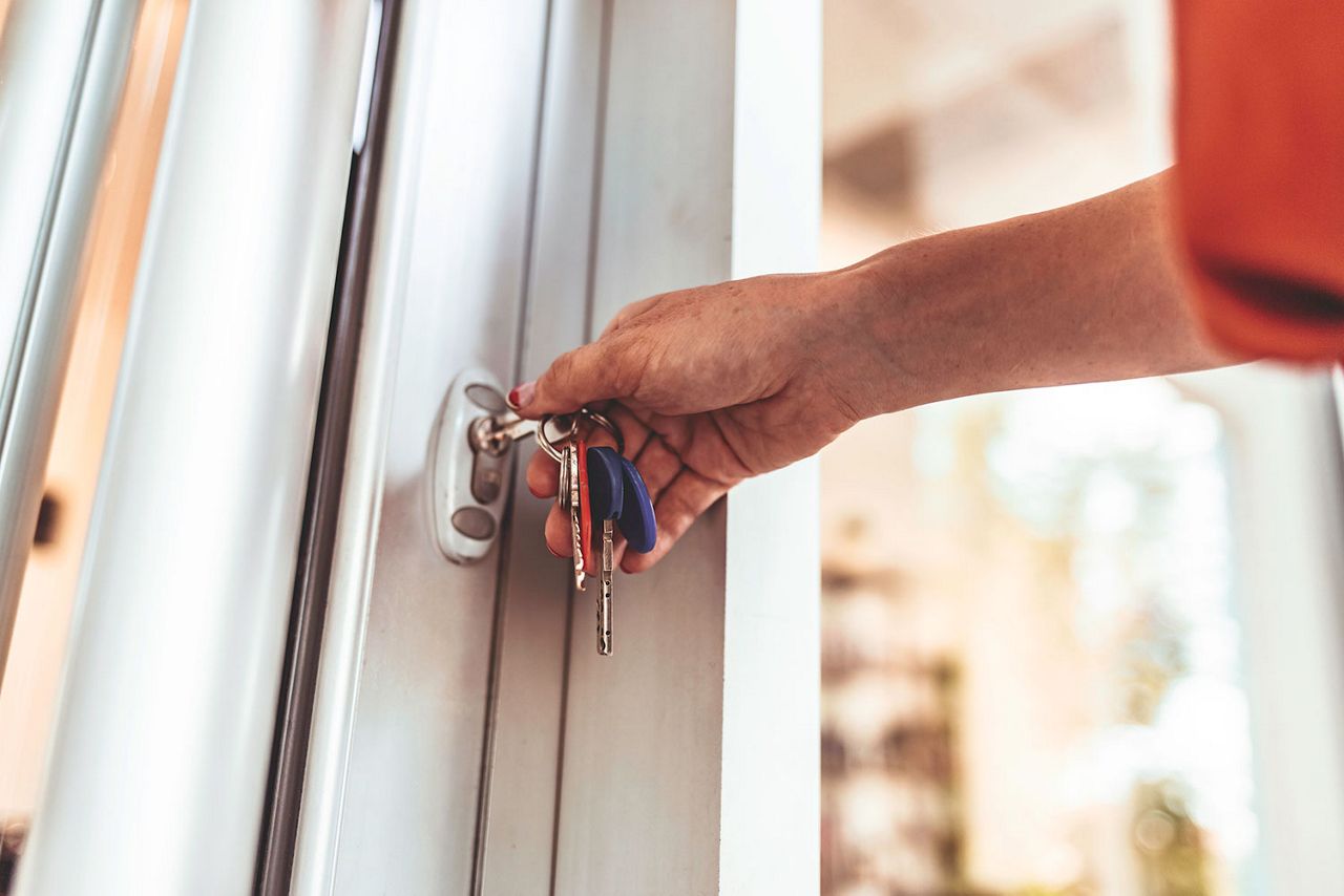 Mujer abriendo con una llave la puerta de unas instalaciones