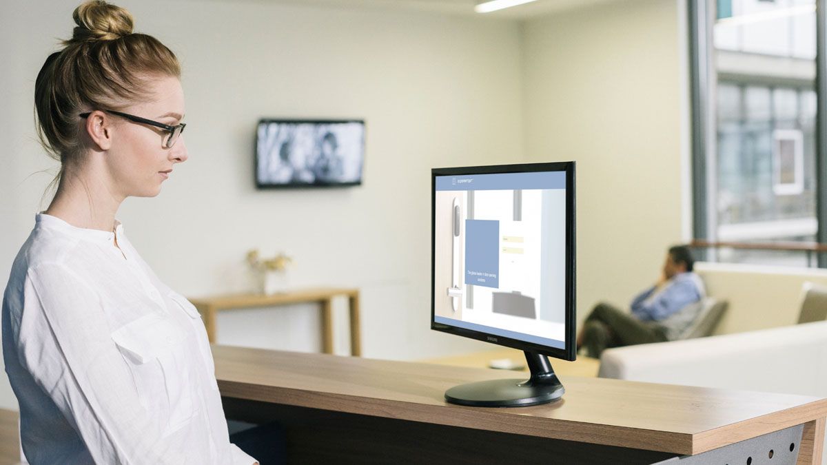 Sygeplejeske står ved en computer