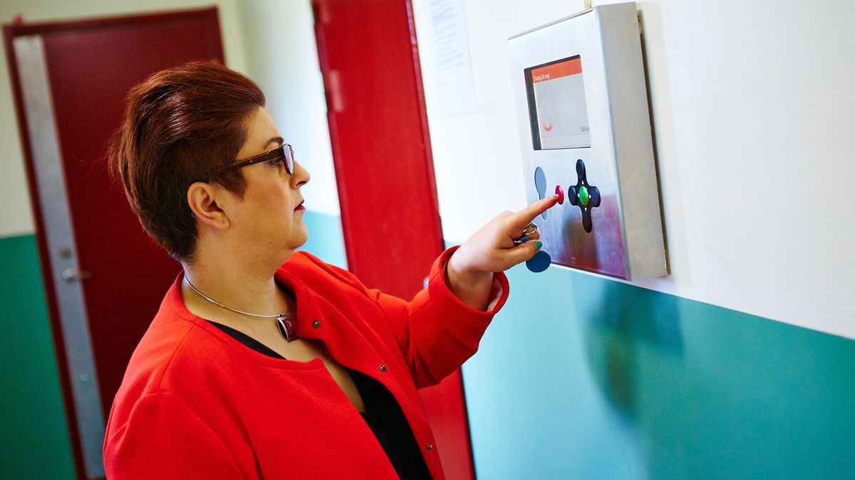 Kvinde trykker på en Aptus Booking tavle