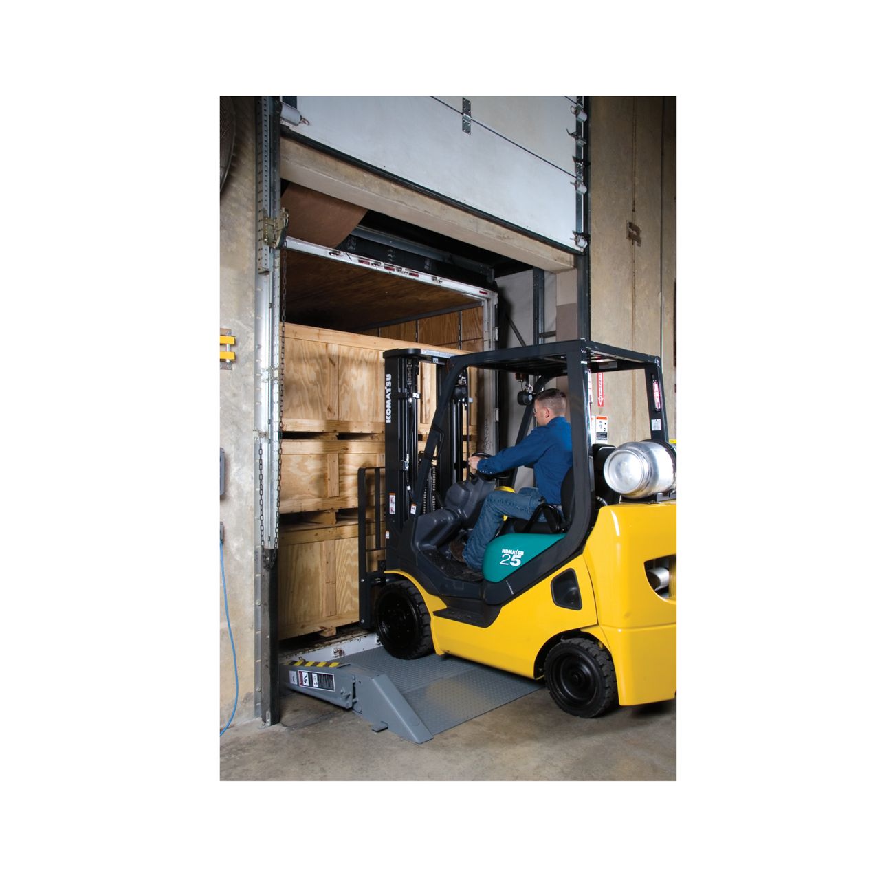 View of surface-mounted dock bridge in use with an unloading truck picking up the boxes at a warehouse.