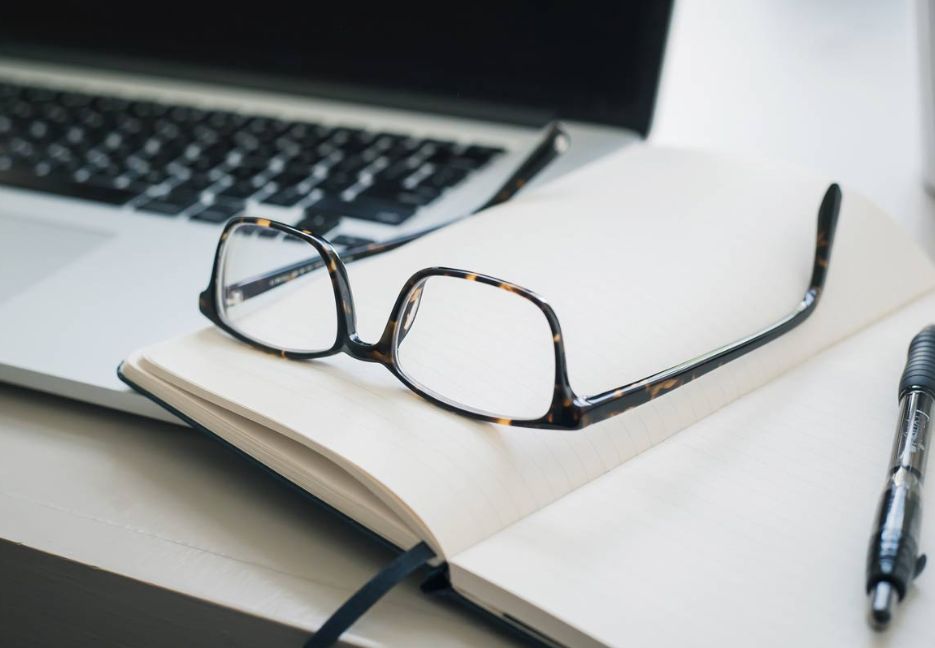 Ordinateur portable, notebook et une paire de lunettes colorées tortue.