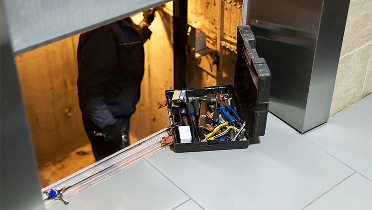 Aufzugstechniker mit Schlüsseln bei der Reparatur eines Aufzugs