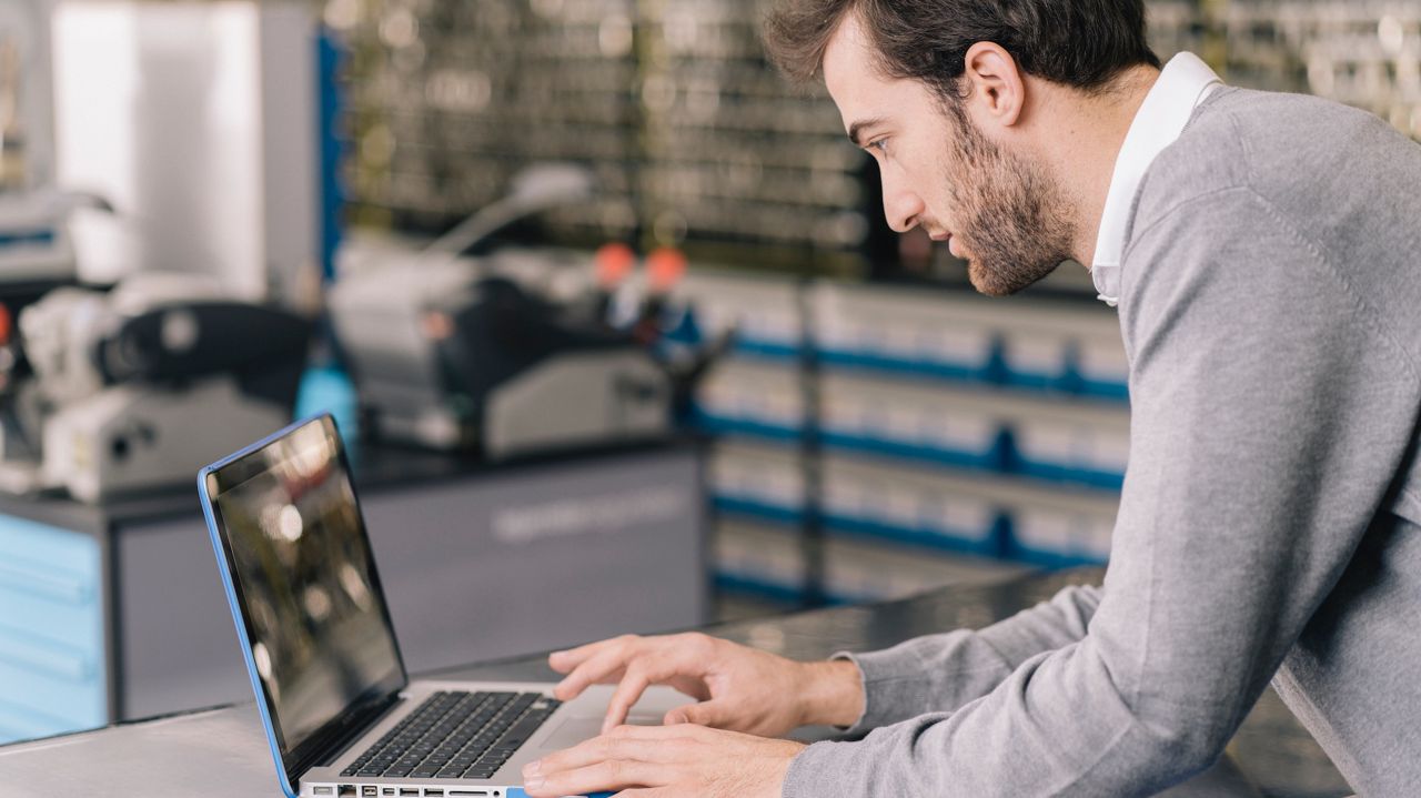 Låsesmed jobber ved datamaskinen.