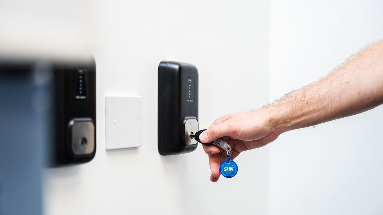 PROTEC2 CLIQ key being updated with a wall PD by a London Ambulance Service employee