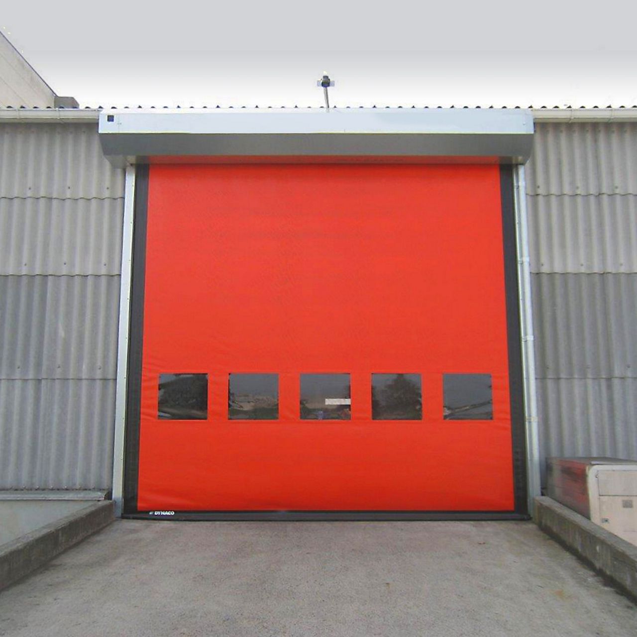 A red high-speed door installed outside.