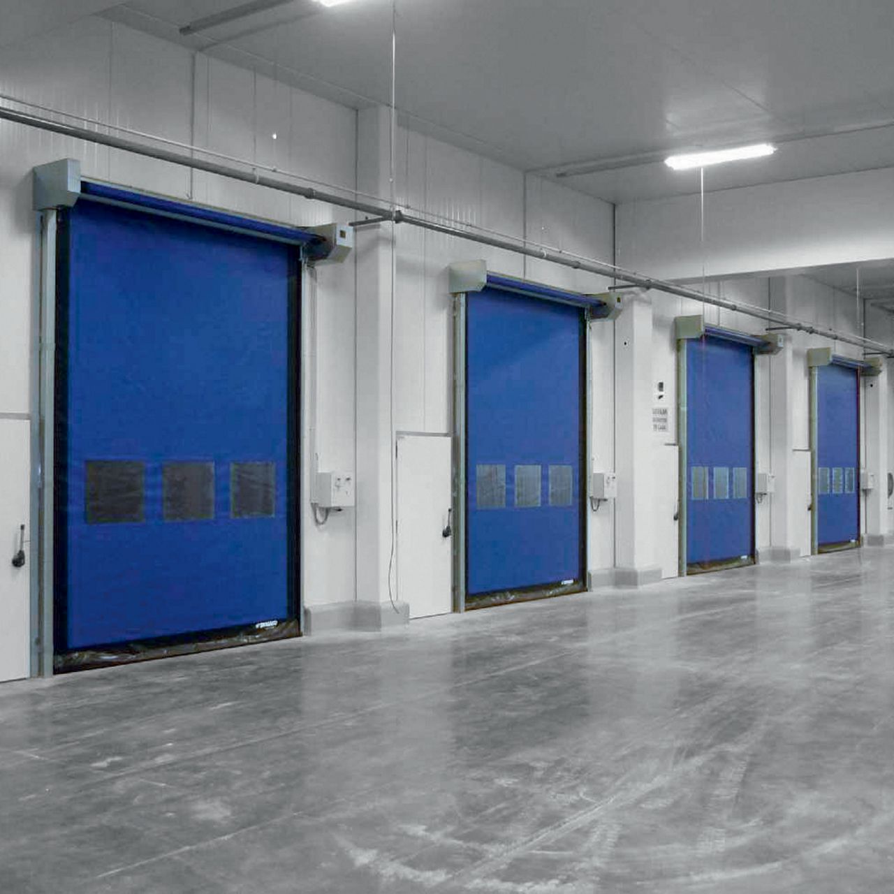 A grey corridor with blue high speed doors.