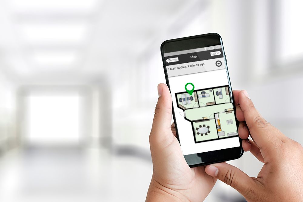 Holding a phone with 9Solutions app and a map
