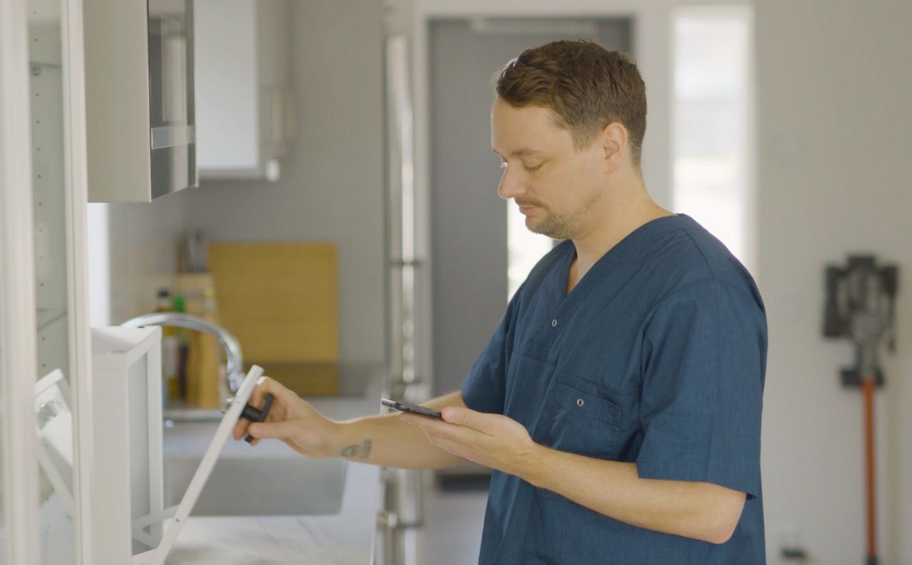 omsorgspersonal öppnar digitalt medicinskåp välfärdsteknik