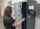 Woman removing a long gun from a Traka modular locker system
