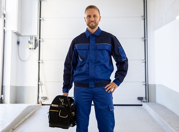 Techniker mit Tasche in der Hand vor einem Sektionaltor
