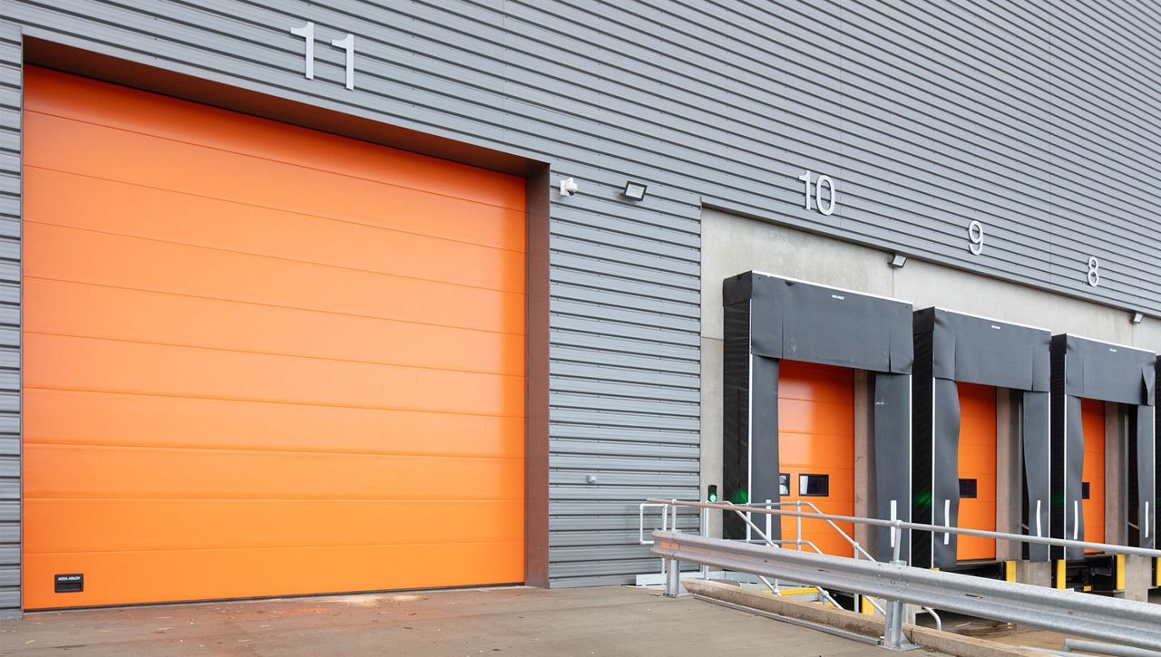 External image of a ASSA ABLOY OH1082P overhead sectional door with orange panels