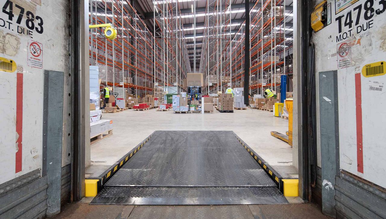 ASSA ABLOY OH6120T Telescopic dock leveller sat on the bed a lorry trailer in a warehouse