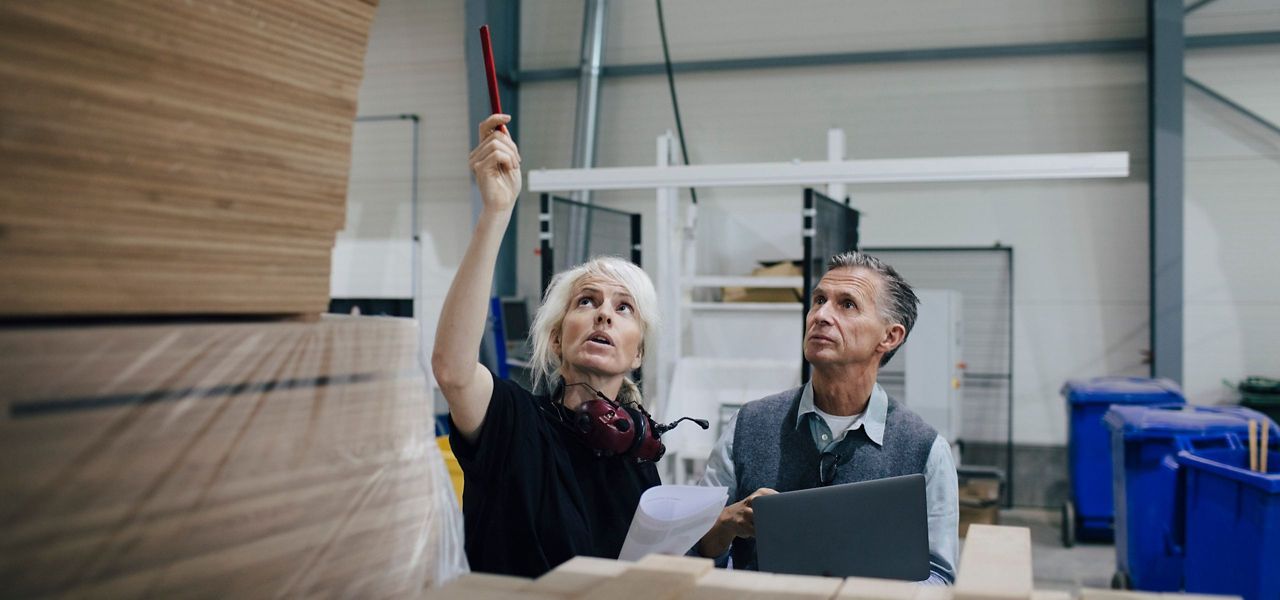 Older Woman And Man Working In A Warehouse