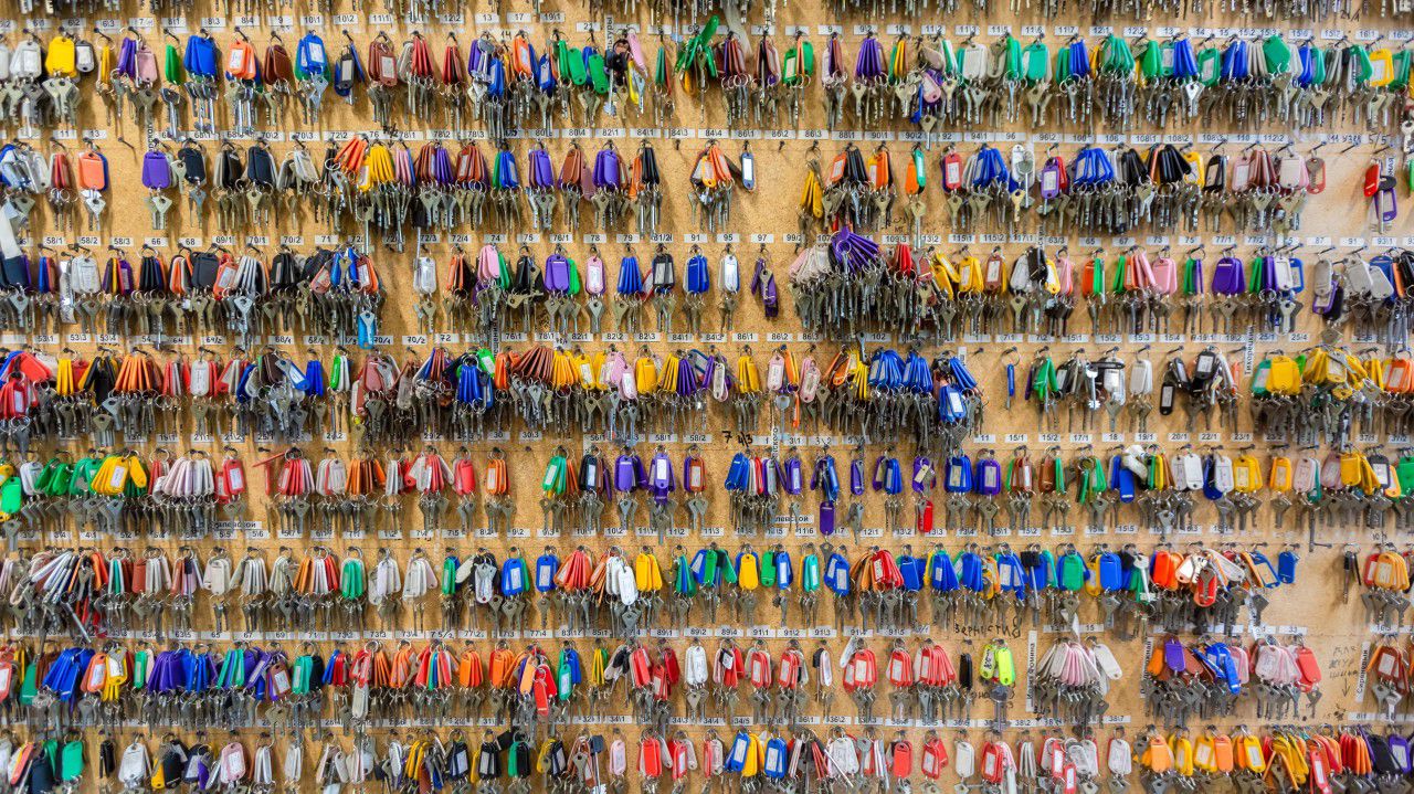 Hundreds of keys hanging on a large peg board