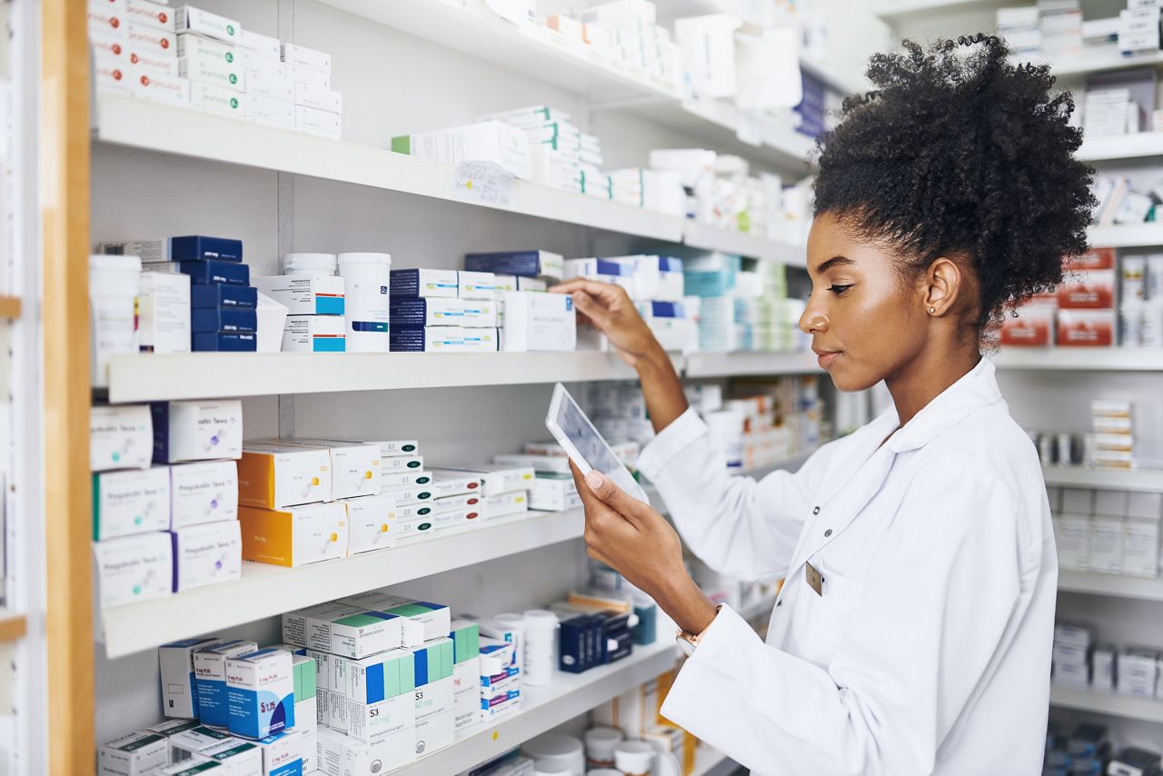 Pharmacist using a tablet to inventory medications