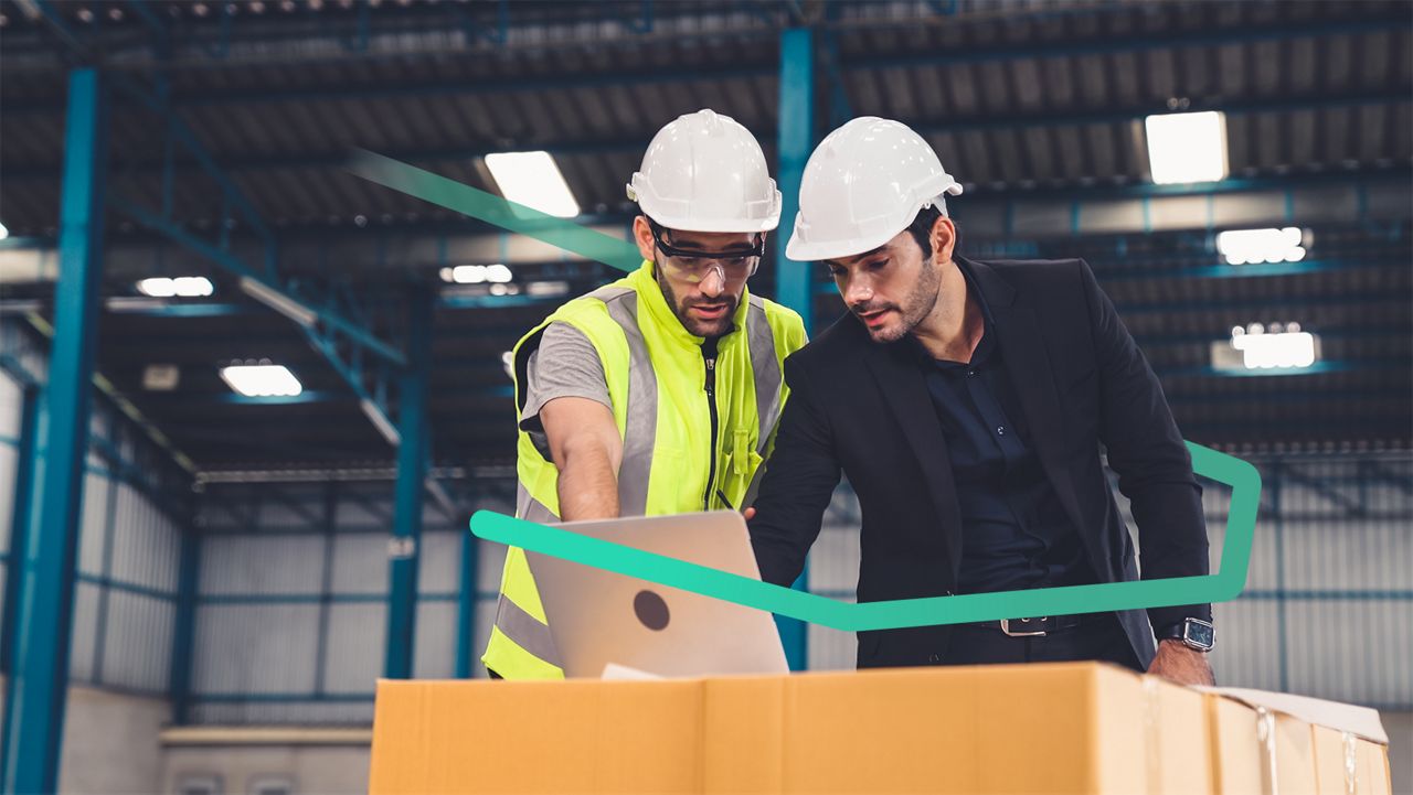 Deux personnes travaillant ensemble sur un ordinateur dans une zone logistique.