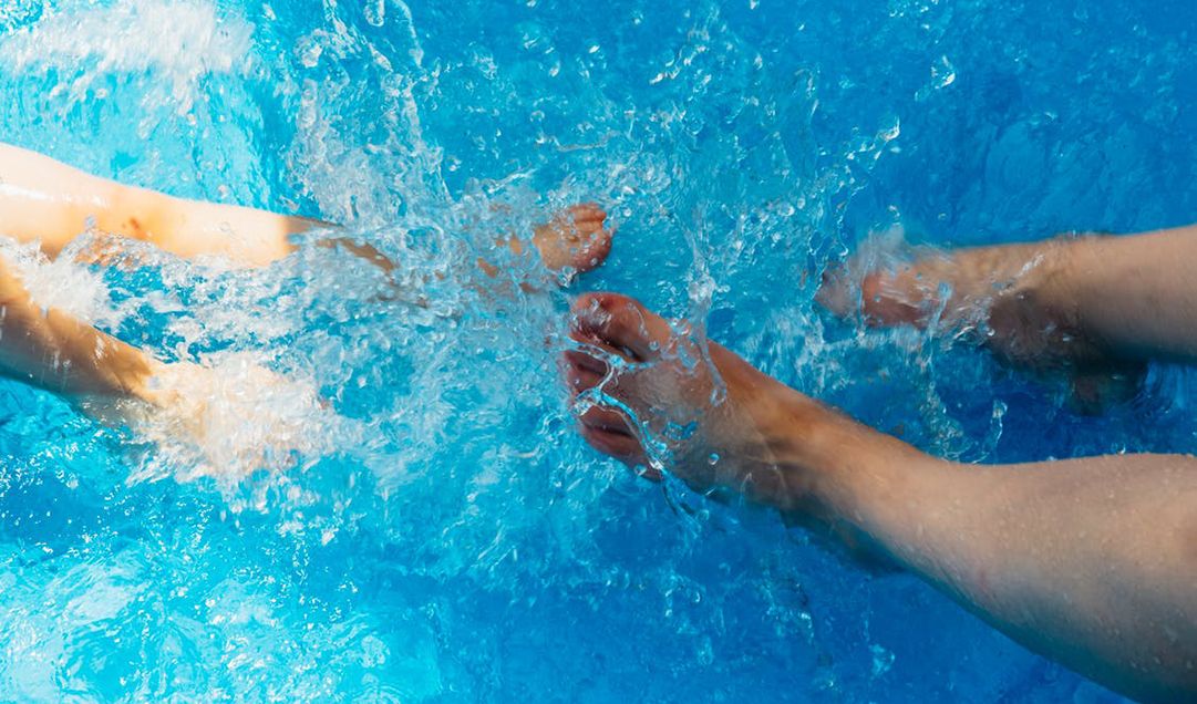 Feet splashing in a pool.
