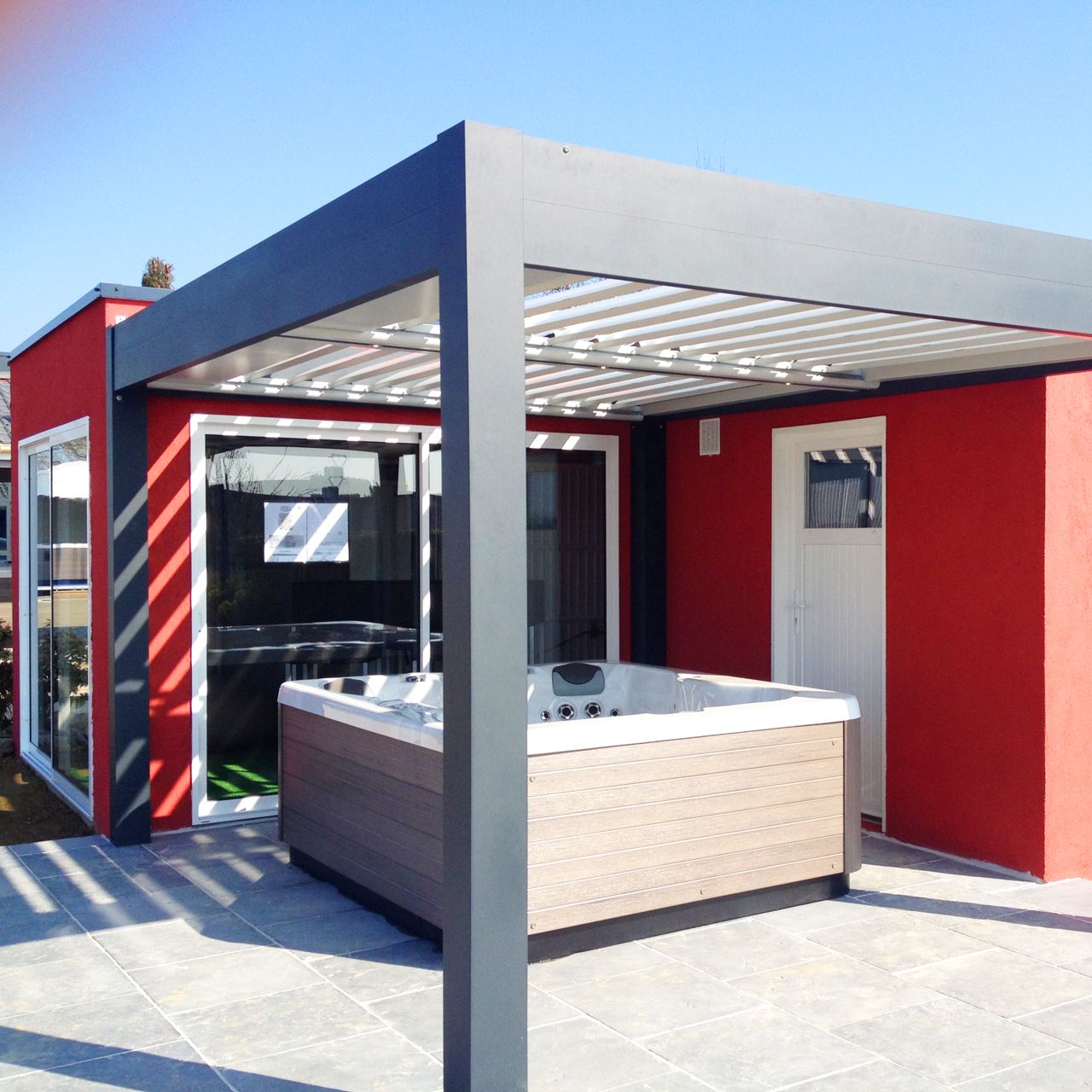 Pergola bioclimatiques grise couvrant un jacouzzi