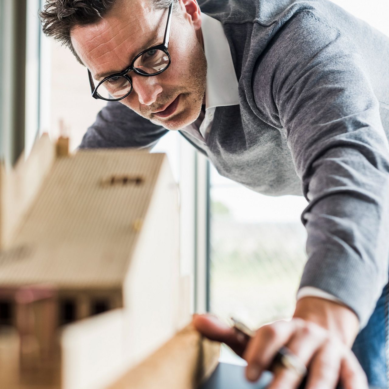 Manlig arkitekt som tittar på en modell.