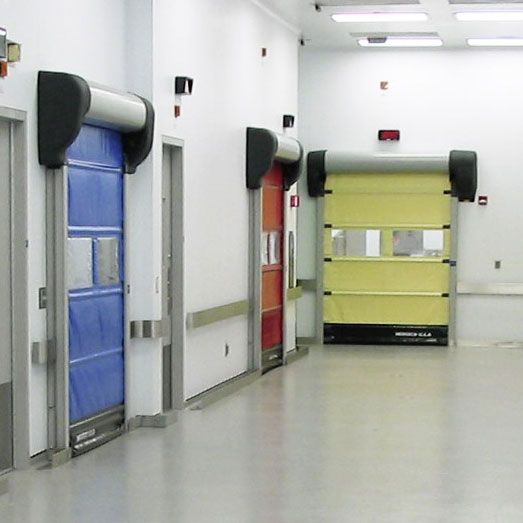 A picture of a corridor with several doors. One yellow, blue and red. 
