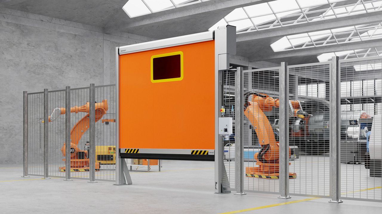 Orange ASSA ABLOY RP400 i öppet läge med maskiner i drift bakom ett staket