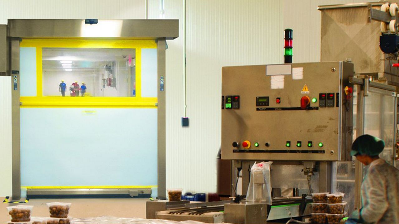 A yellow door in a factory that handle food. 