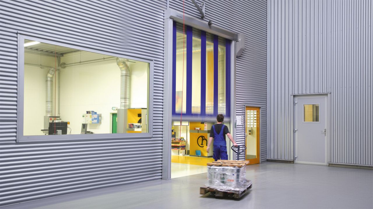 Image: ASSA ABLOY RR355 viewed in an indoor environment, half open with a person walking towards it