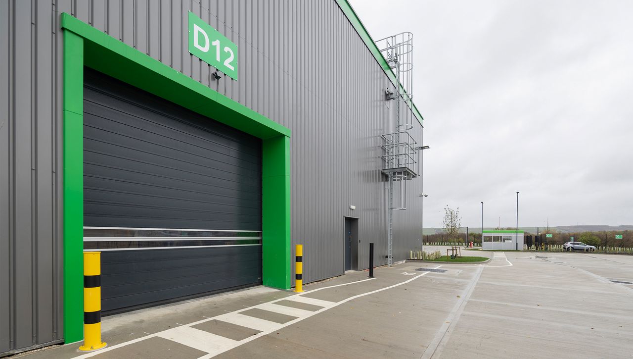Image: External view of an ASSA ABLOY RR5000 Insulated Exterior Door with clear lamellas providing site onto the yard at  Schneider Electric