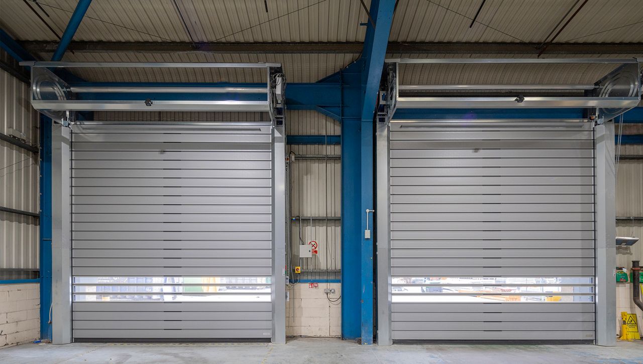 Image: Interior view of two ASSA ABLOY RT1000 high-speed spiral doors with horizontal vision panels, installed in a logistics facility